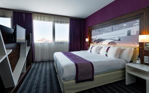 a hotel room with a large bed and a tv at Holiday Inn Toulouse Airport by IHG in Blagnac