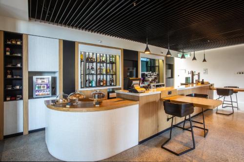 a bar in a restaurant with a counter and chairs at Holiday Inn Telavi by IHG in Tʼelavi