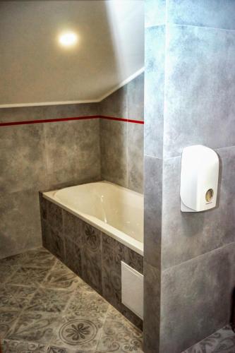 a bathroom with a tub and a toilet paper dispenser at Східний in Brzezhany