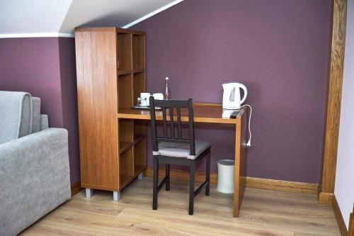 a desk with a chair next to a purple wall at Східний in Brzezhany