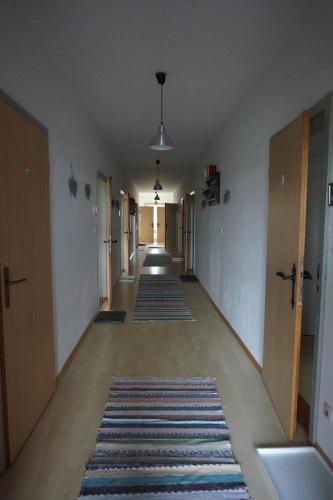 an empty hallway with a row of rugs on the floor at Viehberghütte in Sandl