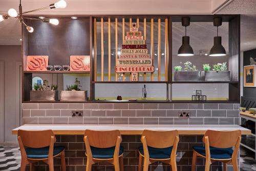 a restaurant with a table and four chairs at Holiday Inn Taunton M5, Jct25 by IHG in Taunton