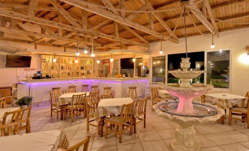 restauracja ze stołami i bar z fioletowym oświetleniem w obiekcie Kasapakis Hotel & Apartments w mieście Hersonissos