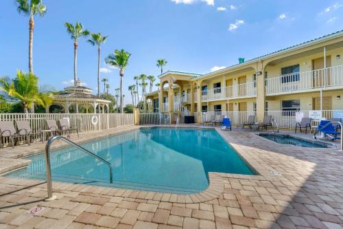 una piscina frente a un edificio con palmeras en Quality Inn Bradenton North I-75, en Bradenton