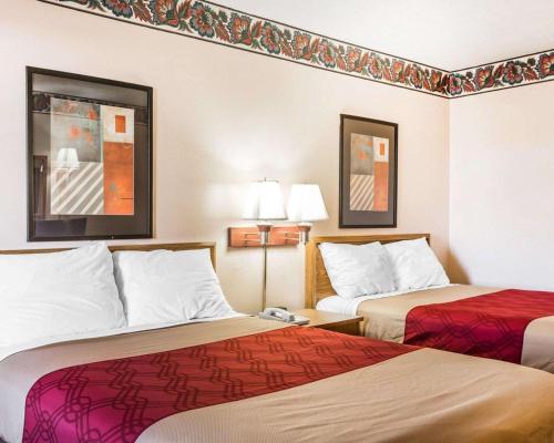 a hotel room with two beds and two lamps at Econo Lodge McDonough South in McDonough