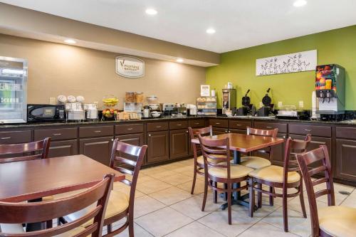 Un restaurante con mesas y sillas y una cocina. en Sleep Inn I-95 North Savannah, en Port Wentworth