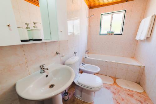 Genuino House في أورتا: حمام أبيض مع حوض ومرحاض