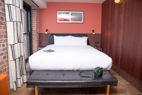 a bedroom with a bed and a red wall at The Mayson in Dublin