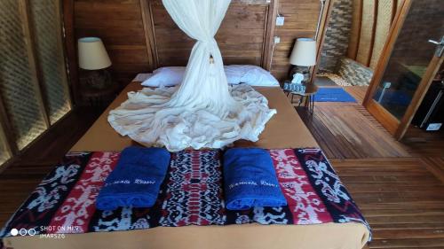 Una cama con dos almohadas y un vestido. en Wajonata Sumba, en Baing