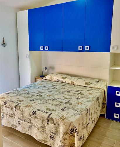 a bedroom with a bed with blue cabinets at Borgo Bellavista Isola Rossa in Isola Rossa