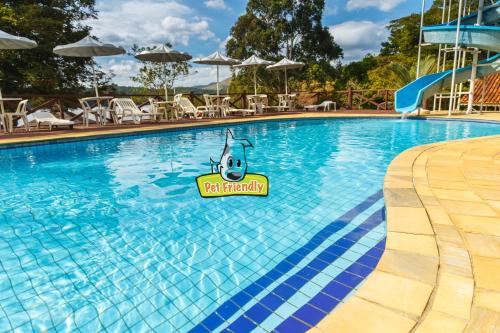 a pool at a resort with a sign in the water at Marina e Pousada Porto do Sol in Nazaré Paulista