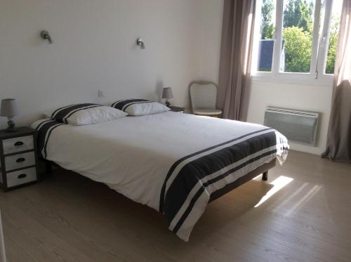 a bedroom with a large bed and a window at Appartement vue mer in Bénodet