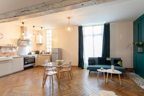 a kitchen and living room with a table and a couch at LE CARPE DIEM in Tours