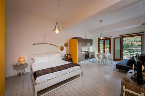 a bedroom with a bed and a living room at Veranda sul Porticciolo in Castellammare del Golfo