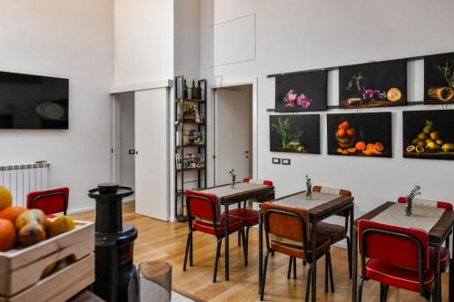 a dining room with two tables and red chairs at Ballarooms B&B Palermo Centro in Palermo