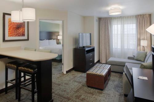 a hotel suite with a living room and a bedroom at Staybridge Suites Fayetteville by IHG in Fayetteville