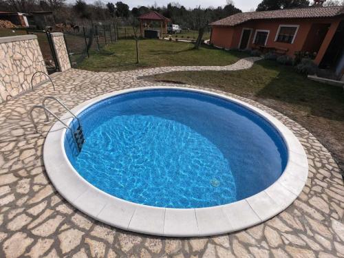 a large blue swimming pool in a yard at Attractive Holiday Home with Pool bubble bath Patio Courtyard in Barbariga