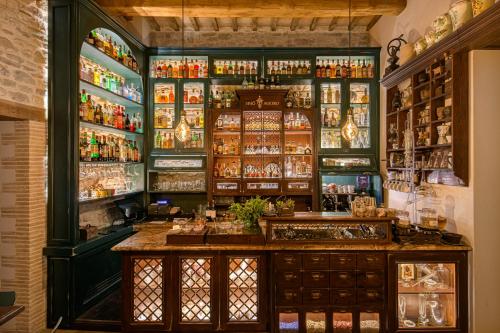 a bar with green walls and shelves with alcohol at Borgo Antichi Orti Assisi in Assisi