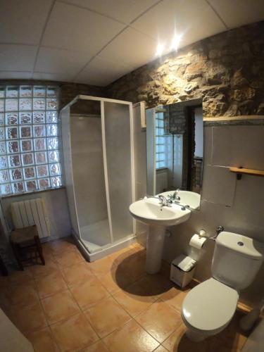 een badkamer met een douche, een toilet en een wastafel bij xalet l’avella 2 in Catí