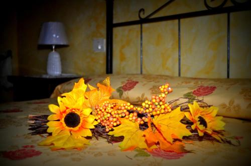 ein Strauß Herbstblätter und Blumen auf dem Bett in der Unterkunft Centro Storico in Anagni