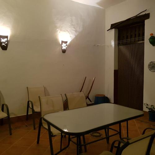 a table and chairs in a room with a wall at Casa los Tres Aires in El Rocío