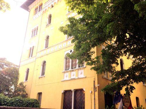 a yellow building with a tree in front of it at Hotel Europa in Perugia
