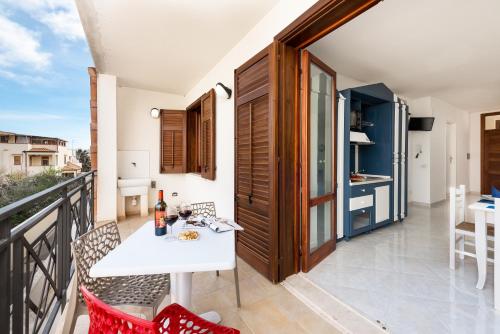 a balcony with a white table and chairs on it at Le Palme Di Conturrana in San Vito lo Capo