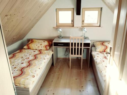 a tiny house with two beds and a desk at apartma HIŠKA KOROŠEC in Bohinj