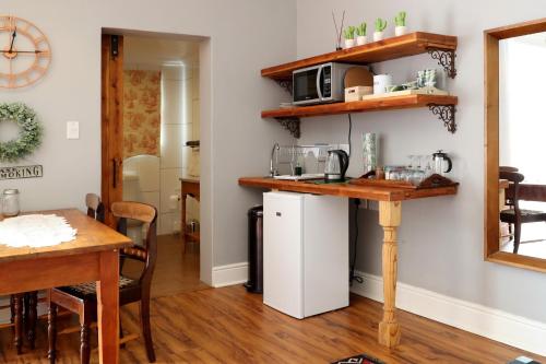 a kitchen with a white refrigerator and a table at The Fancy Cactus in Colesberg