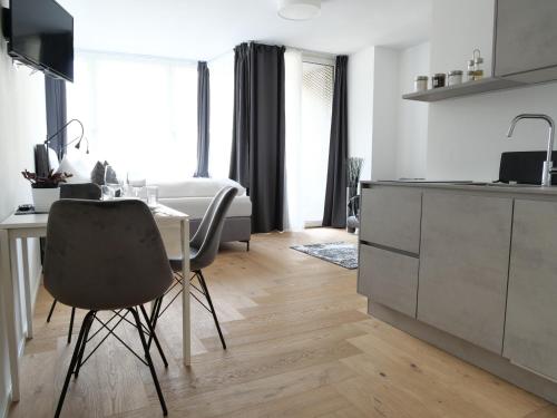 a kitchen with a desk and a table with a chair at Apartments Sabine K in Merano