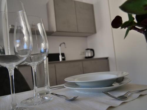 a table with two wine glasses and a bowl on it at Apartments Sabine K in Merano