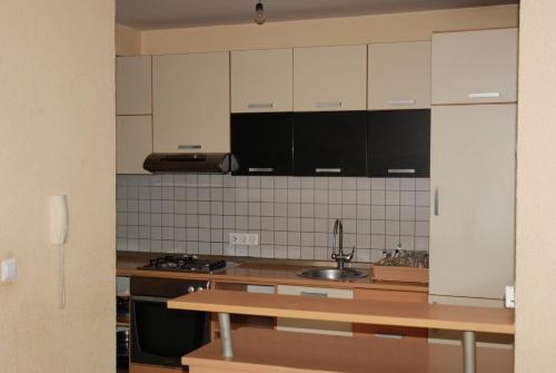 a kitchen with white cabinets and a sink at Vila Ratković in Banja Luka