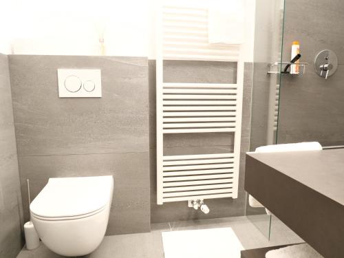 a bathroom with a white toilet and a shower at Apartments Sabine K in Merano