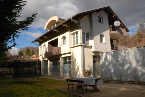 een wit huis met een bankje ervoor bij Vila Ratković in Banja Luka