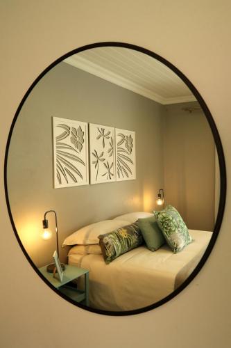 a bedroom with a bed with a round mirror at The Fancy Cactus in Colesberg