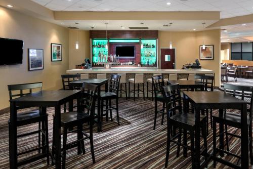 a bar with black tables and chairs in a restaurant at Holiday Inn Los Angeles Gateway-Torrance by IHG in Torrance