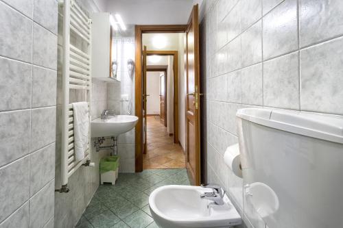Baño blanco con lavabo y aseo en Fiume & Zannoni Apartments by 360Rentals, en Florencia