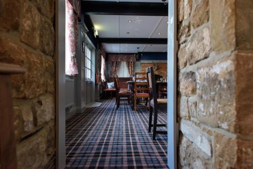 
a room with a table, chairs, and a door at Devonshire Arms Inn in Cracoe
