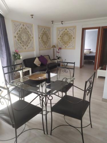 sala de estar con mesa, sillas y sofá en Apartamento Balcón de Europa 2A en Nerja