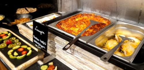 a display case with a pizza and other food at Baobab Suites in Siófok