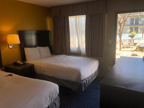 a hotel room with two beds and a window at Howard Johnson by Wyndham Odessa TX in Odessa