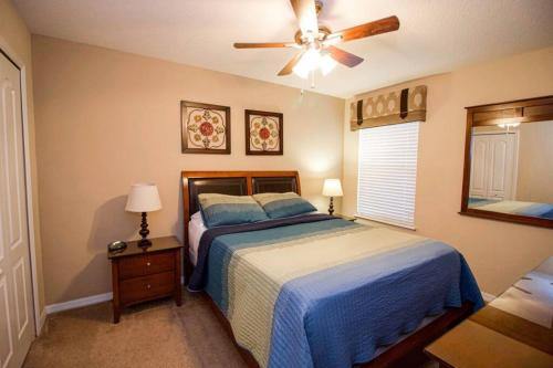 a bedroom with a bed and a ceiling fan at Tuscany at Westside Luxury 5 Bed, 4 Bath Villa near Disney in Kissimmee