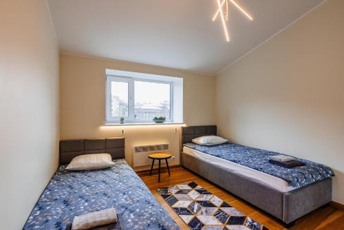 タリンにあるAirHome - Palm Tree Penthouseの窓のある小さな部屋にベッドが2つある