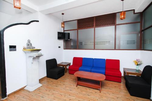 a living room with a red and blue couch at Sea view Beach Resort in Unawatuna