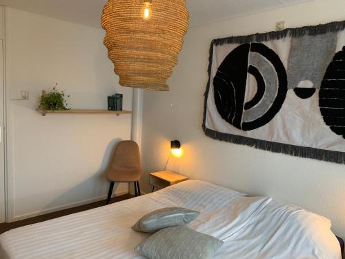 a bedroom with a bed and a painting on the wall at Appartement 1 aan het strand met hond in Zoutelande