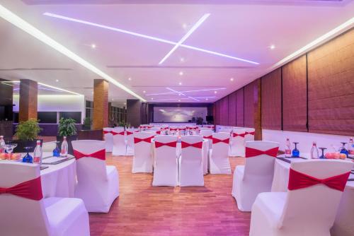 a banquet hall with white tables and red bows at Crowne Plaza Kochi by IHG in Cochin