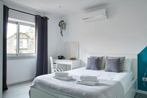 - une chambre blanche avec un lit et une fenêtre dans l'établissement Alegria 79 - Fabulous 3 Bedroom House, à Coimbra
