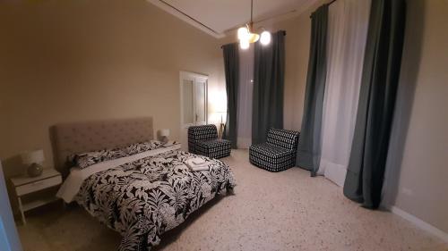 a bedroom with a bed and two chairs and a window at Palazzetto di Neubourg in Naples