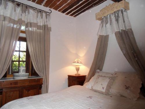 1 dormitorio con 1 cama con cortinas y ventana en La Maison d'Allouma, en La Garde-Freinet