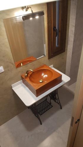 a bathroom with a wooden sink and a mirror at Apartamentos Plan Dulcis in Buera